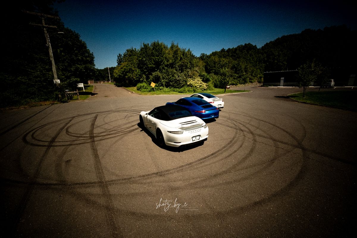 Porsches parked on a lot with tire marks